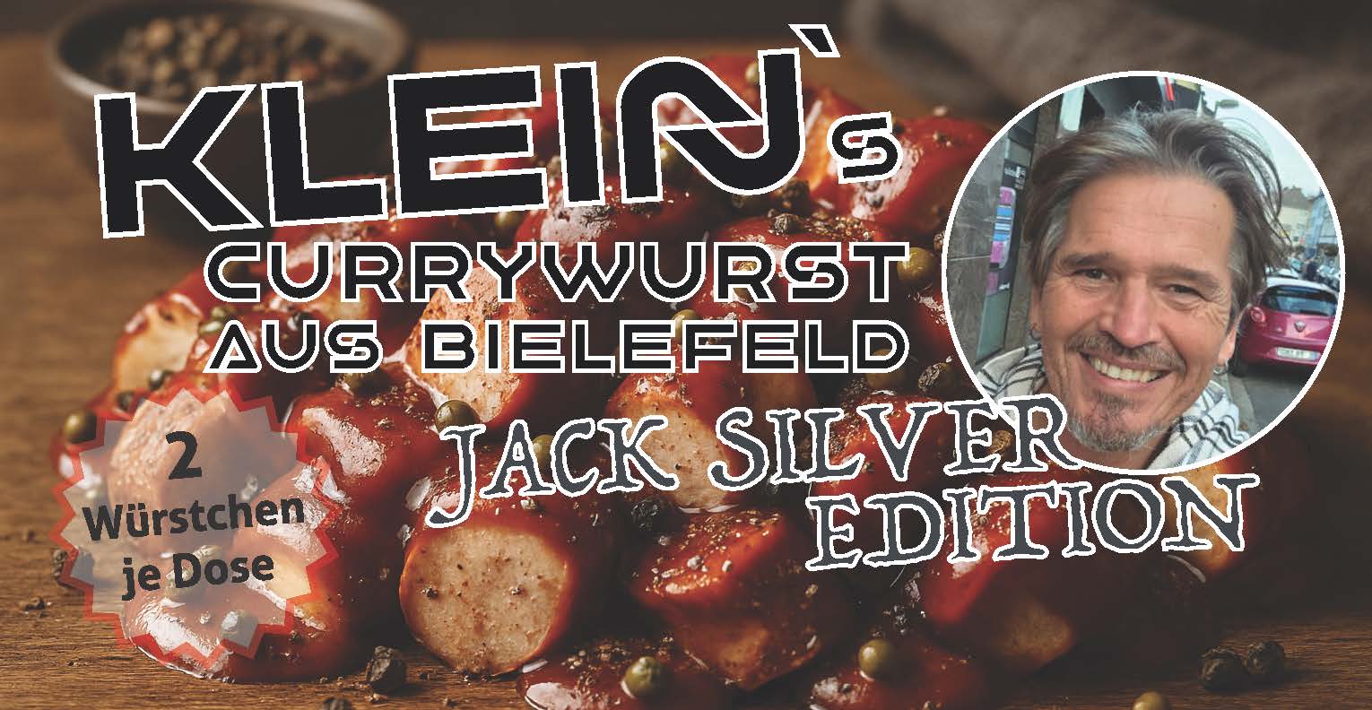 Etikett der Klein’s Currywurst aus Bielefeld Jack Silver Edition. Im Hintergrund sind mit Pfefferkörnern gewürzte Currywurststücke zu sehen. Auf der rechten Seite befindet sich ein rundes Porträtfoto eines Mannes. Text: „2 Würstchen je Dose“